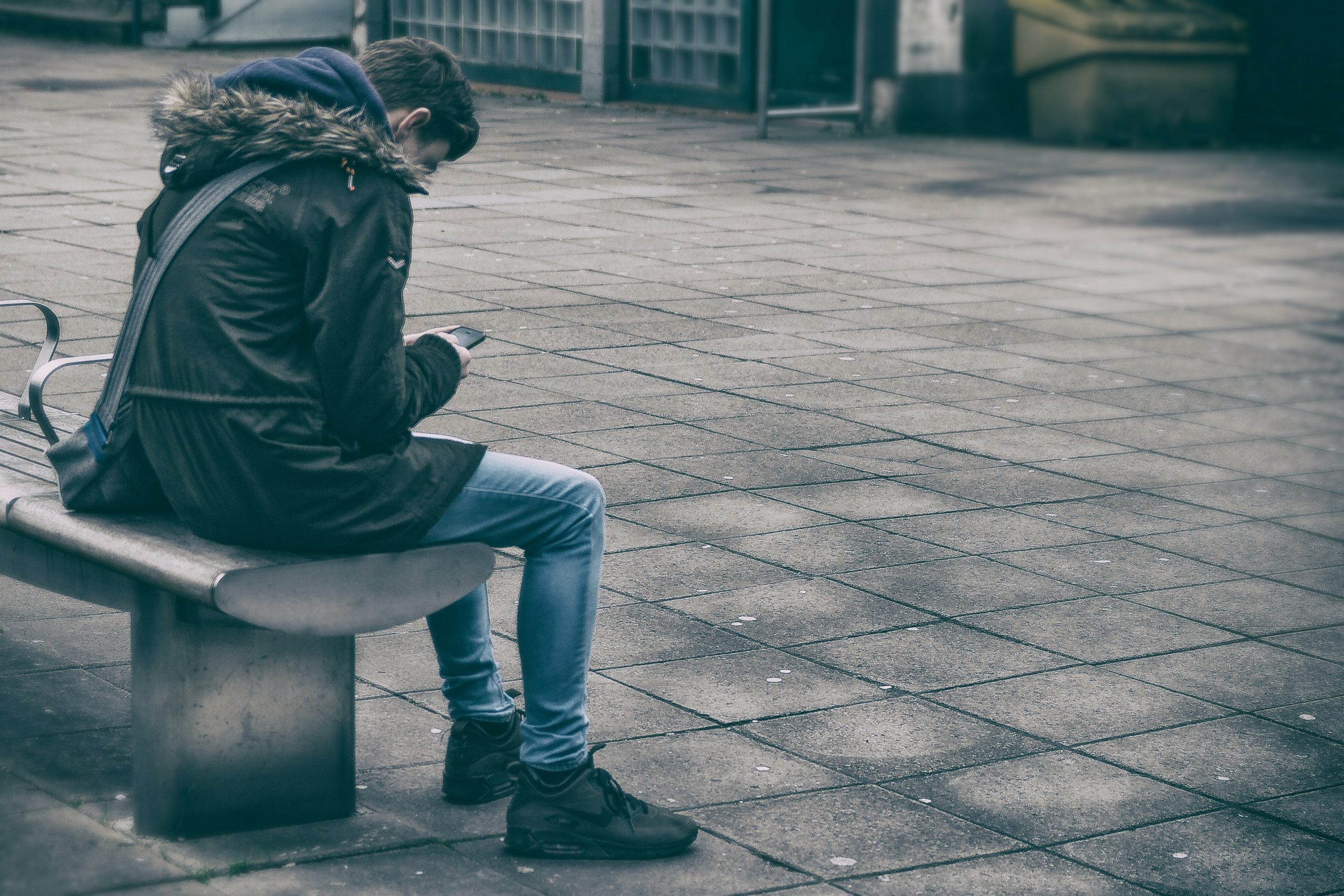 man sitting on bench holding phone